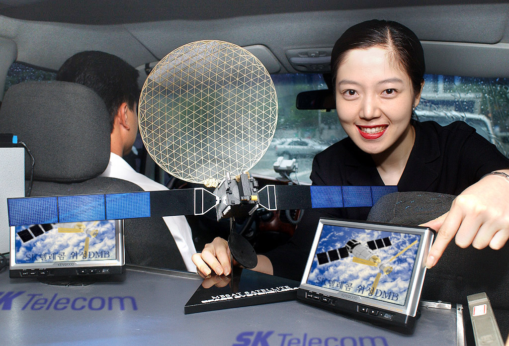 The customer is shown watching DMB broadcasting program with vehicle installment type mobile terminal through the pilot satellite DMB service.